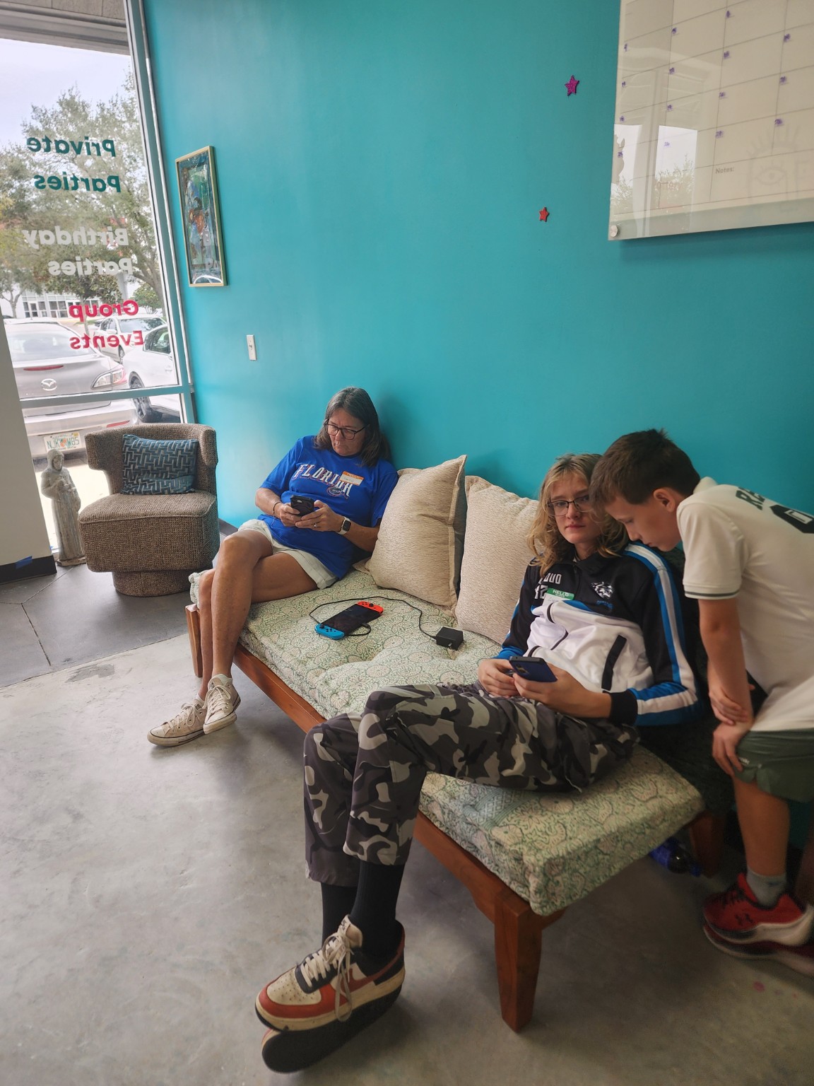Families relaxing in the teal-walled studio lounge