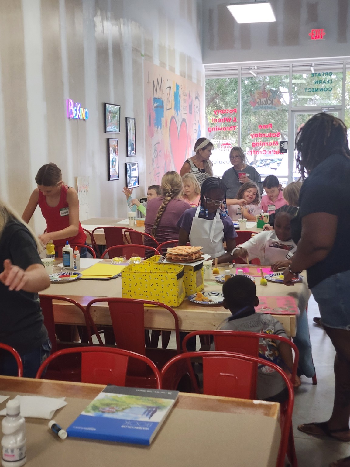 Children and adults creating together around a long craft table