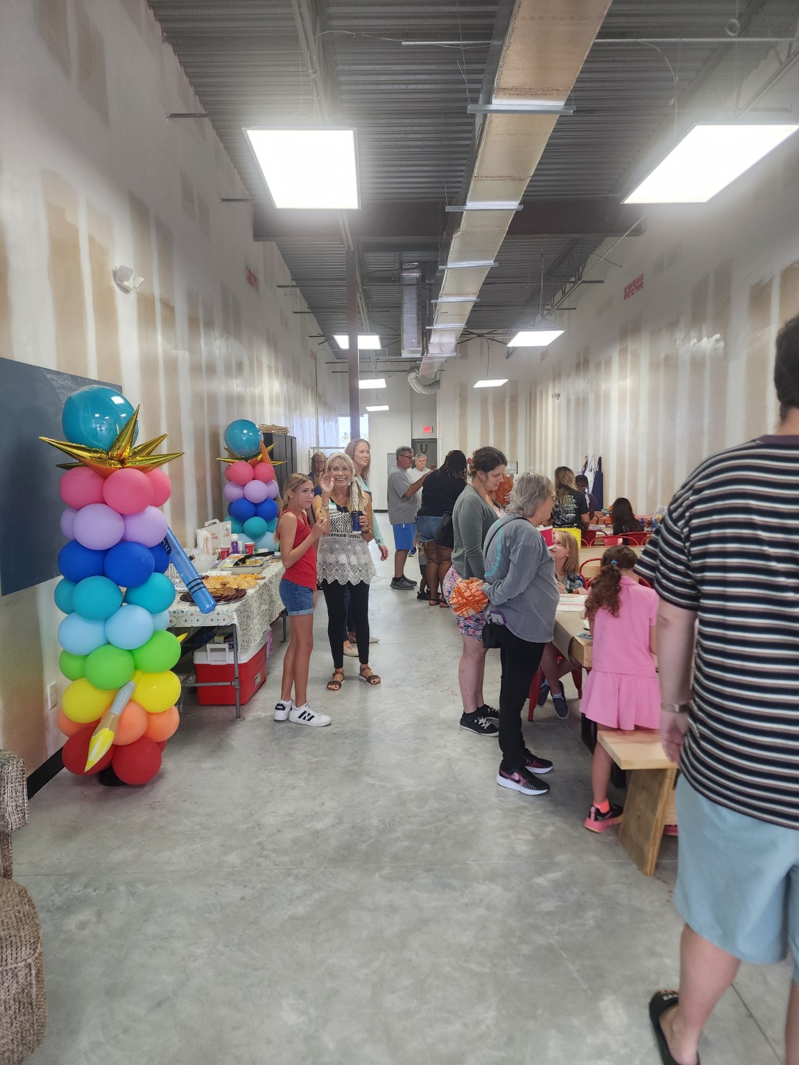 Guests gathering beside colorful balloons and craft tables in the studio